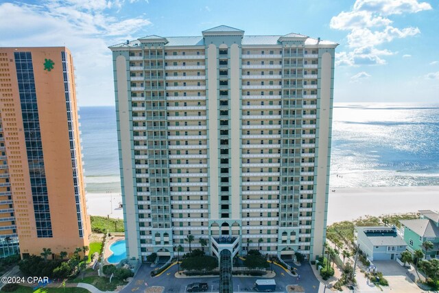 view of building exterior featuring a water view and a view of the beach