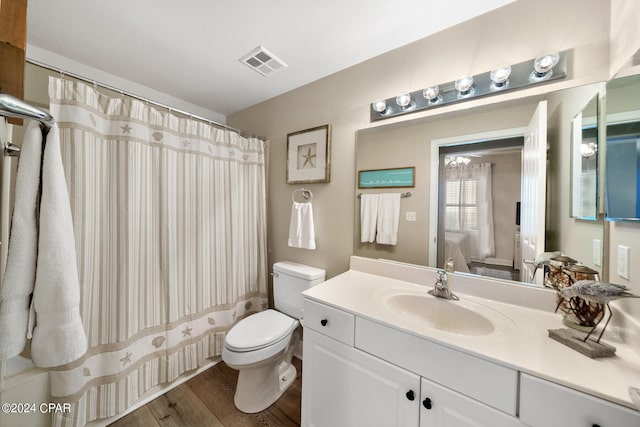 bathroom featuring curtained shower, hardwood / wood-style floors, vanity, and toilet