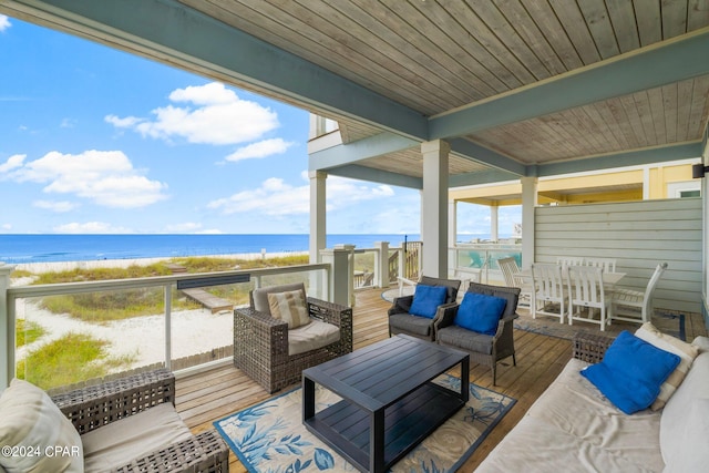 deck featuring a water view, a beach view, and an outdoor hangout area