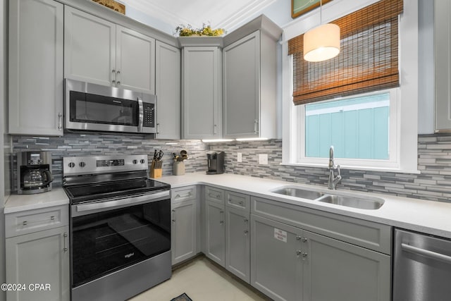 kitchen with backsplash, appliances with stainless steel finishes, sink, and gray cabinets