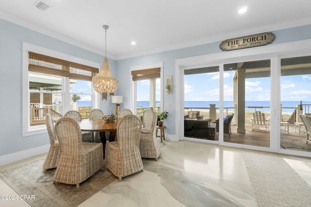 dining space featuring crown molding, a notable chandelier, and a water view