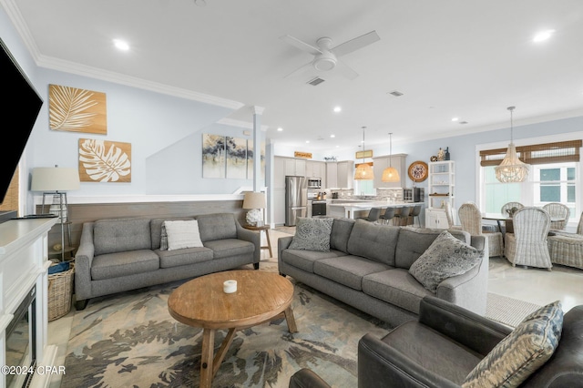 living room featuring ornamental molding and ceiling fan with notable chandelier