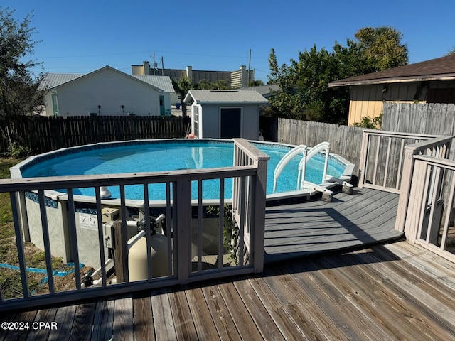 view of swimming pool with a wooden deck and an outdoor structure