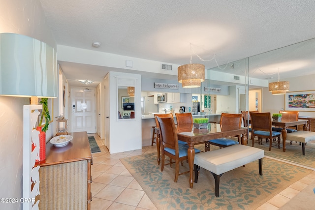 tiled dining area featuring a textured ceiling