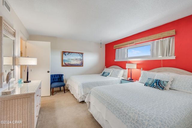 bedroom with a textured ceiling and light carpet