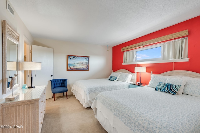 bedroom featuring a textured ceiling and light carpet