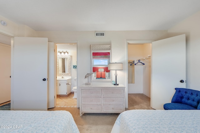 4425 Thomas Dr Unit 707, Panama City, FL 32408 - bedroom featuring light carpet, ensuite bath, and a spacious closet