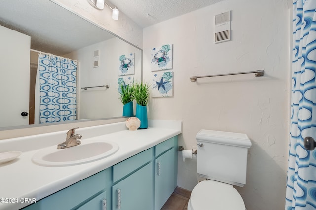 bathroom featuring vanity, a textured ceiling, and toilet