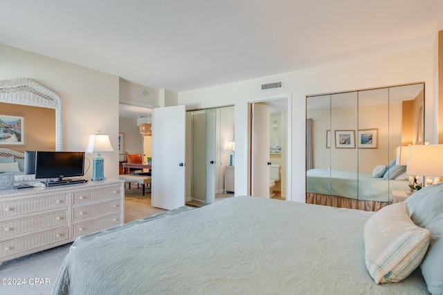 4425 Thomas Dr Unit 707, Panama City, FL 32408 - bedroom featuring multiple closets, light carpet, and ensuite bath
