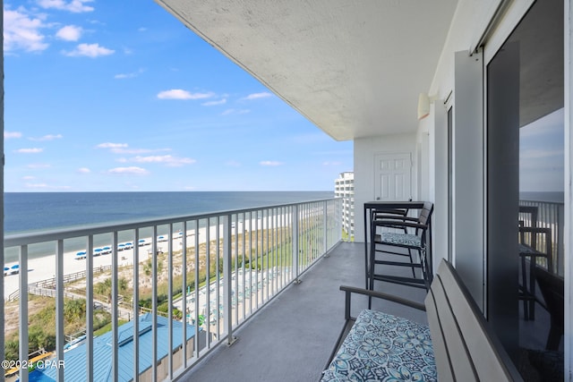 balcony featuring a beach view and a water view