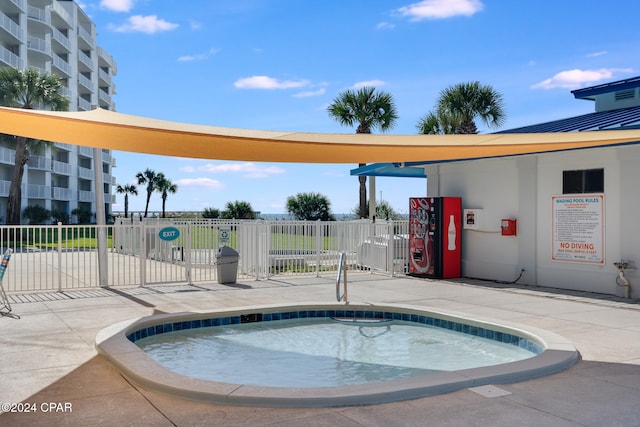 view of swimming pool with a hot tub