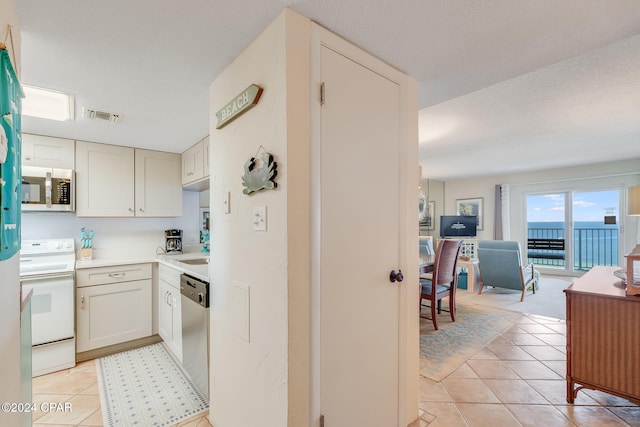 4425 Thomas Dr Unit 707, Panama City, FL 32408 - kitchen with stainless steel appliances, light tile patterned floors, open floor plan, light countertops, and a sink