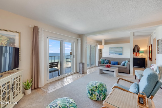 tiled living room with a water view and a textured ceiling