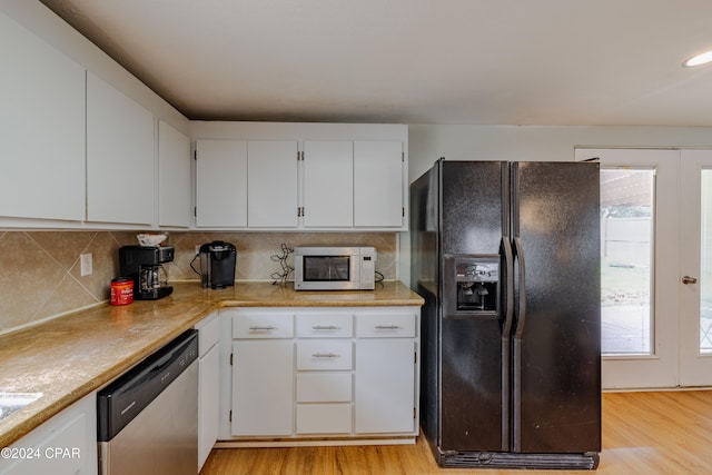 kitchen featuring white cabinets, light wood-type flooring, stainless steel dishwasher, and black fridge with ice dispenser