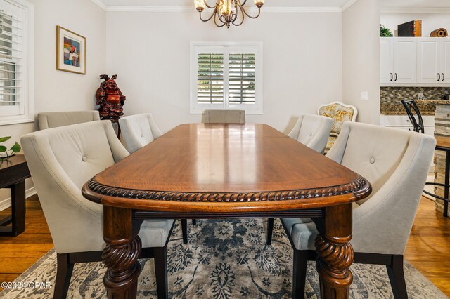 dining room with dark wood-type flooring, crown molding, and a notable chandelier