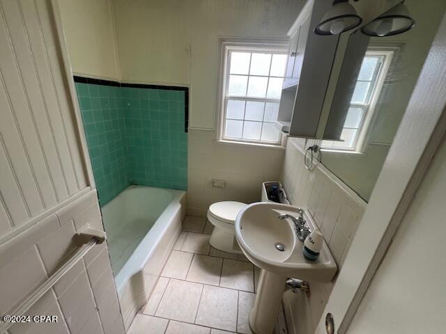 bathroom featuring tile patterned floors, toilet, and a bath