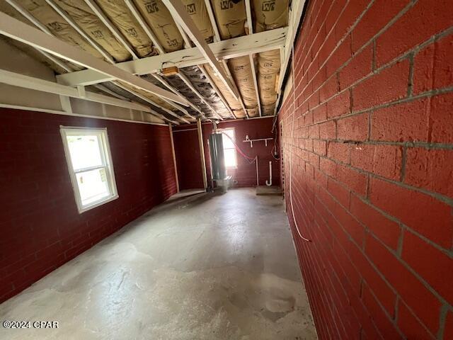 basement with a healthy amount of sunlight and brick wall