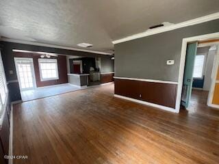 unfurnished living room featuring hardwood / wood-style flooring and crown molding