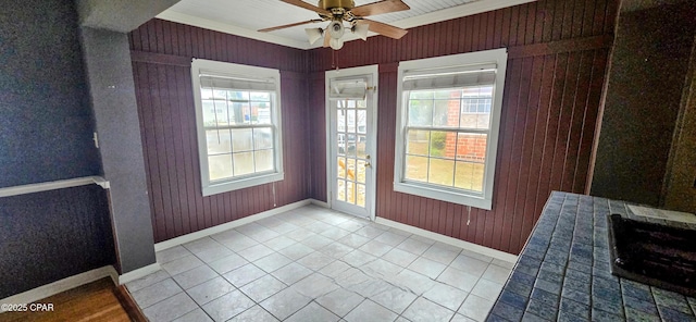 unfurnished sunroom with ceiling fan