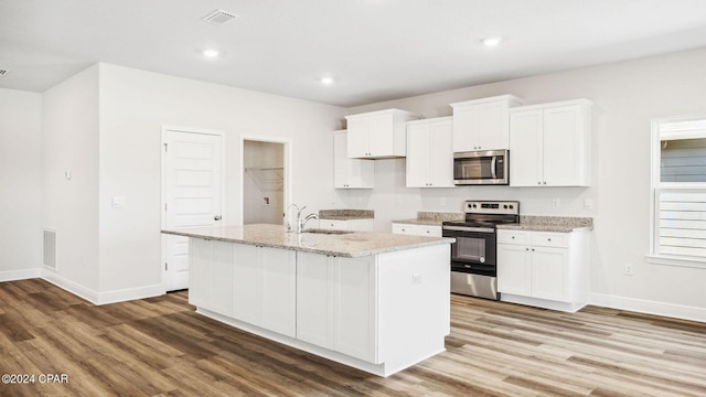 kitchen with a sink, stainless steel appliances, visible vents, and white cabinetry