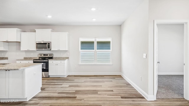 kitchen with appliances with stainless steel finishes, white cabinetry, and baseboards