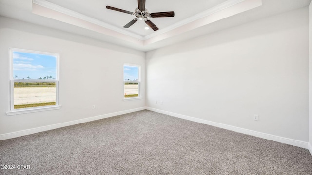 unfurnished room featuring baseboards, carpet, a tray ceiling, ornamental molding, and a ceiling fan