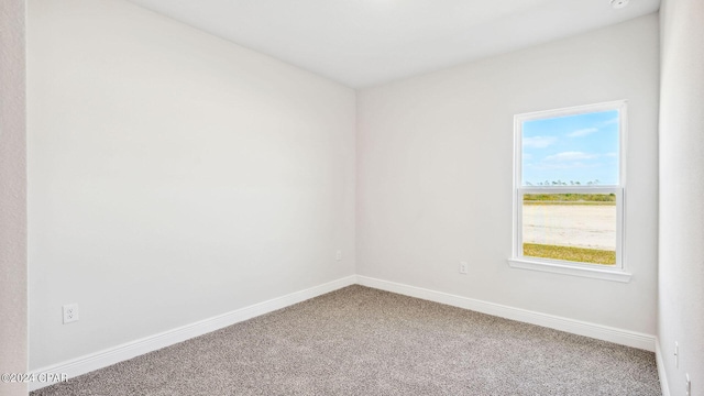 carpeted empty room featuring baseboards