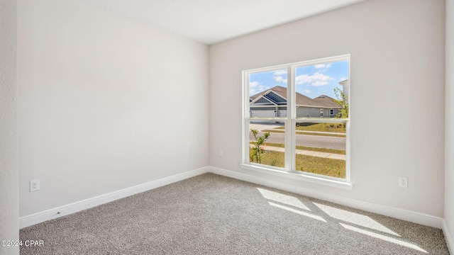 empty room featuring baseboards and carpet