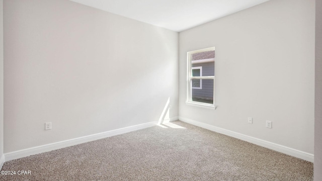 empty room featuring carpet flooring and baseboards