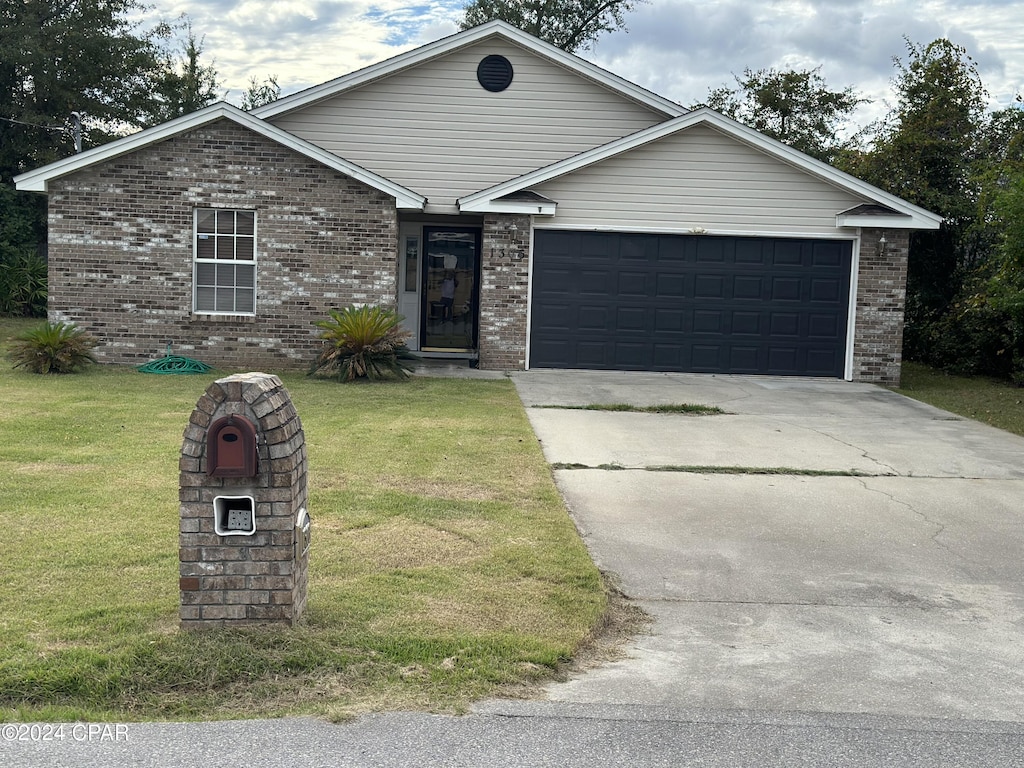 single story home featuring a garage and a front lawn