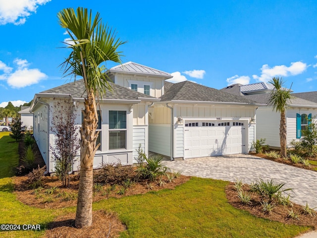 view of front of property with a garage and a front lawn