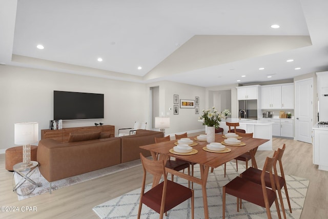 dining room featuring recessed lighting, vaulted ceiling, and light wood-style flooring