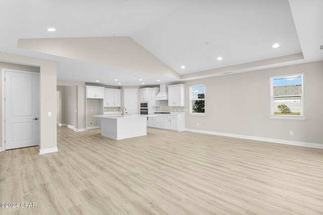 unfurnished living room featuring recessed lighting, a sink, light wood finished floors, and baseboards