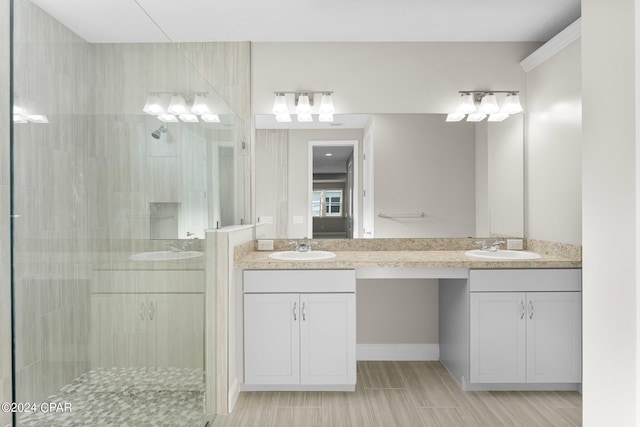 bathroom with a sink, a shower stall, and double vanity