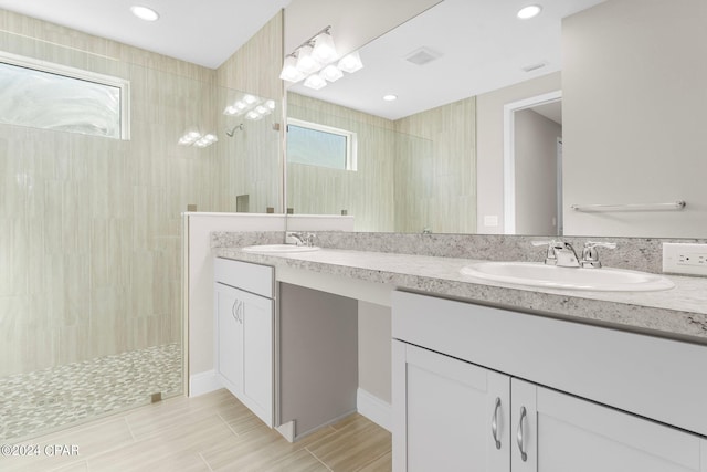 full bath featuring recessed lighting, double vanity, a sink, and a walk in shower