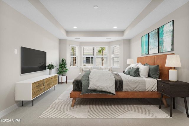 bedroom featuring light carpet, baseboards, a raised ceiling, and recessed lighting