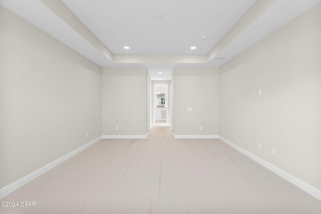empty room featuring light colored carpet, recessed lighting, and baseboards