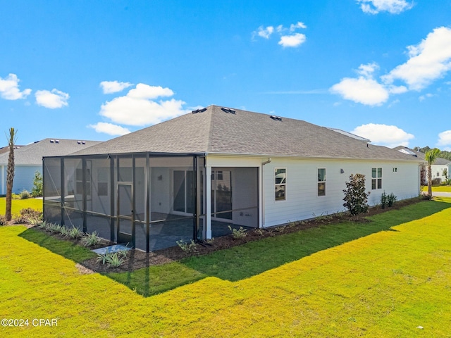 rear view of property with glass enclosure, a lawn, and roof with shingles