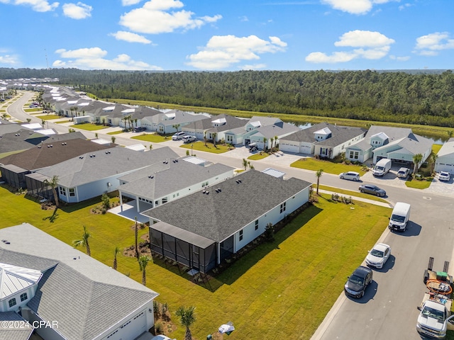 drone / aerial view featuring a residential view and a forest view