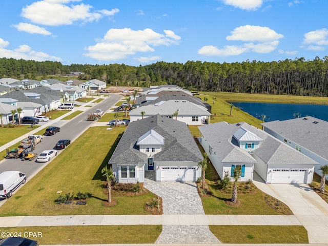 bird's eye view with a water view, a view of trees, and a residential view