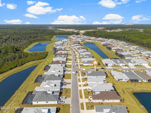 birds eye view of property with a wooded view, a water view, and a residential view