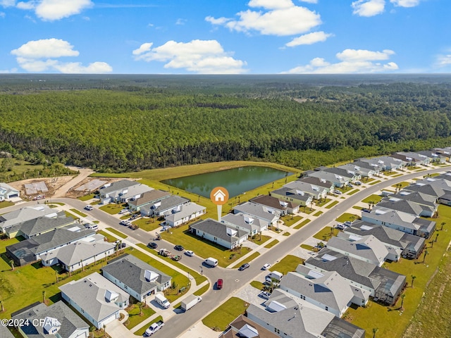 drone / aerial view with a water view, a residential view, and a forest view