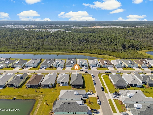 aerial view featuring a forest view, a residential view, and a water view