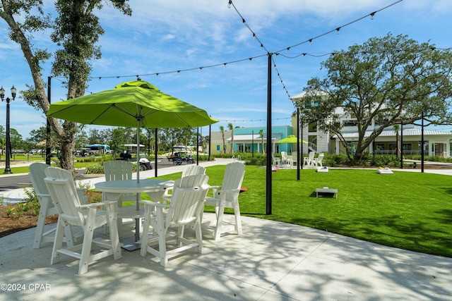 view of community featuring a lawn and outdoor dining space