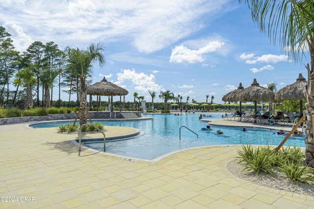 view of swimming pool with a gazebo, a water view, and a patio area