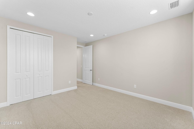 unfurnished bedroom featuring visible vents, recessed lighting, baseboards, and light colored carpet