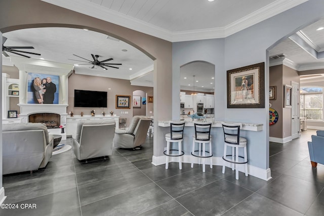 living room featuring ceiling fan and crown molding