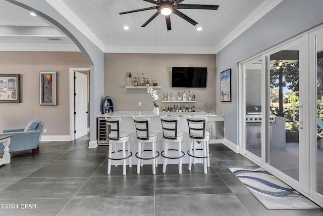 kitchen featuring ceiling fan, a kitchen island, ornamental molding, and wooden ceiling