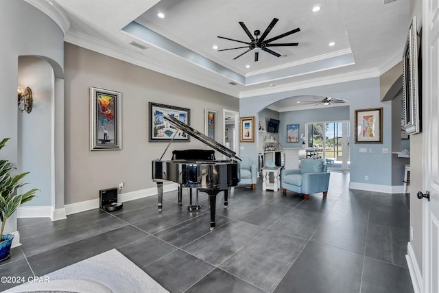 sitting room with ceiling fan, a tray ceiling, and crown molding