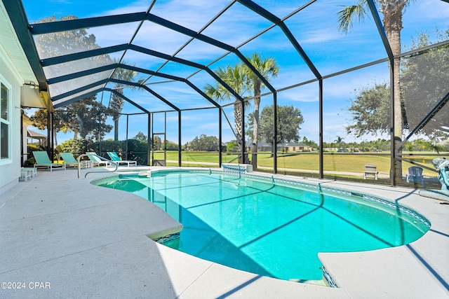 view of pool featuring glass enclosure, a yard, and a patio